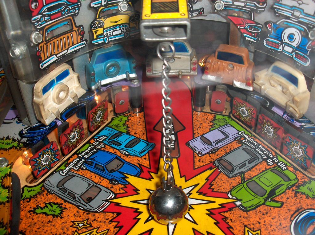 The wrecking ball and five toy cars on a real machine.